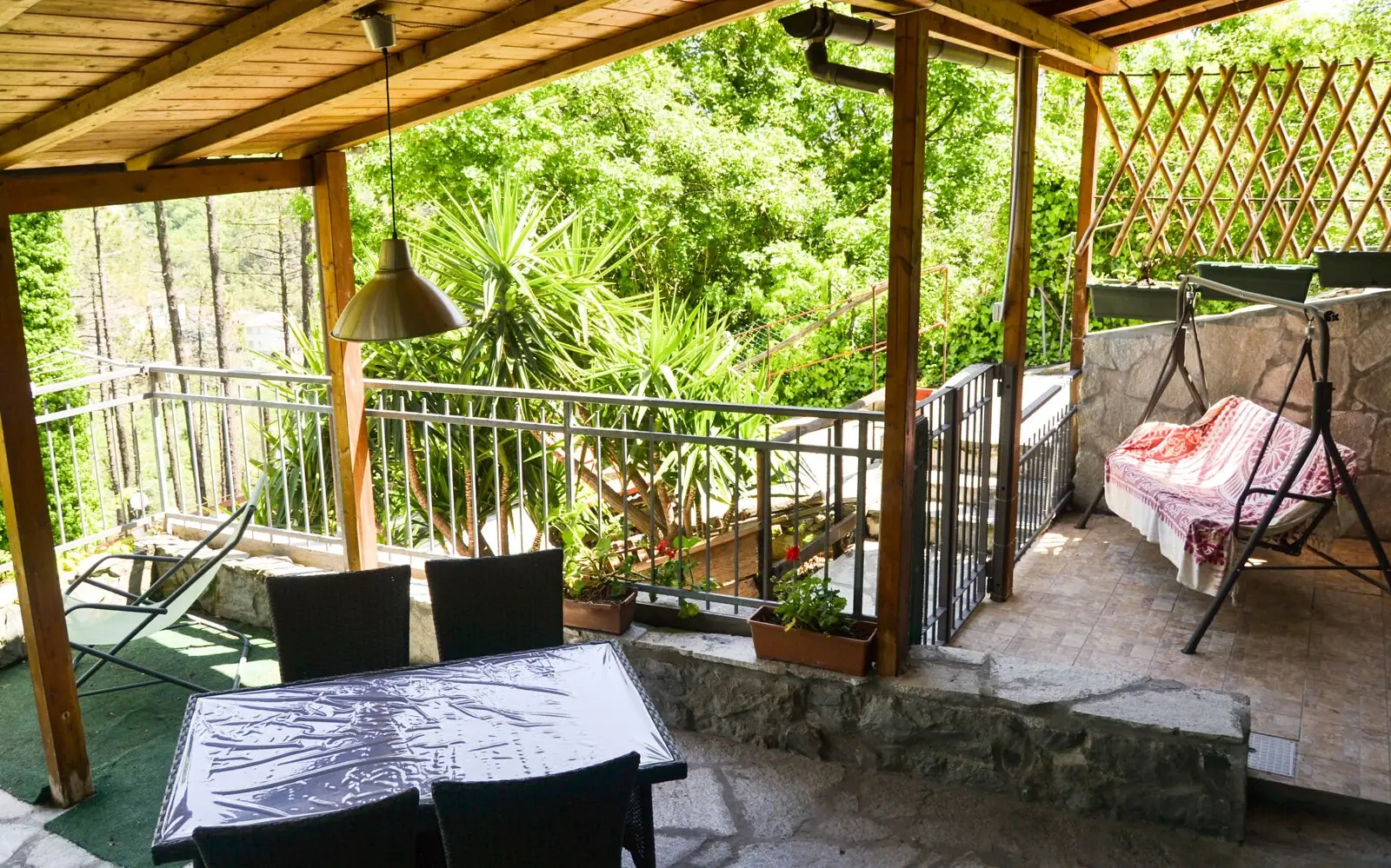 La veranda della Casetta del Nonno Paco con tavolo e dondolo